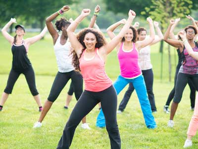 Un grupo de mujeres tomando una clase de ejercicio al aire libre.