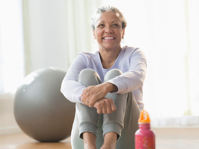 A woman sitting on the floor exercising