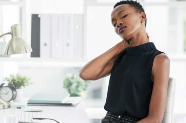 Woman at desk rubbing back of neck