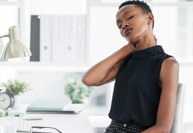Woman at desk rubbing back of neck