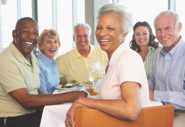 Group of older men and women smiling at dinner