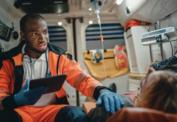An EMS technician in an ambulance with a patient