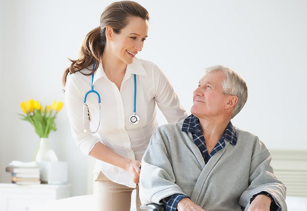Hospital Doctor With Digital Tablet Talks To Male Patient