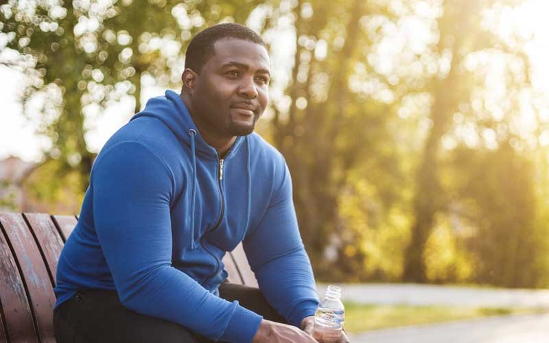 man sitting on bench after exercising