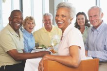 Group of older men and women smiling at dinner