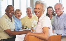 Group of older men and women smiling at dinner