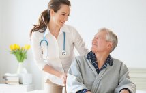 Hospital Doctor With Digital Tablet Talks To Male Patient